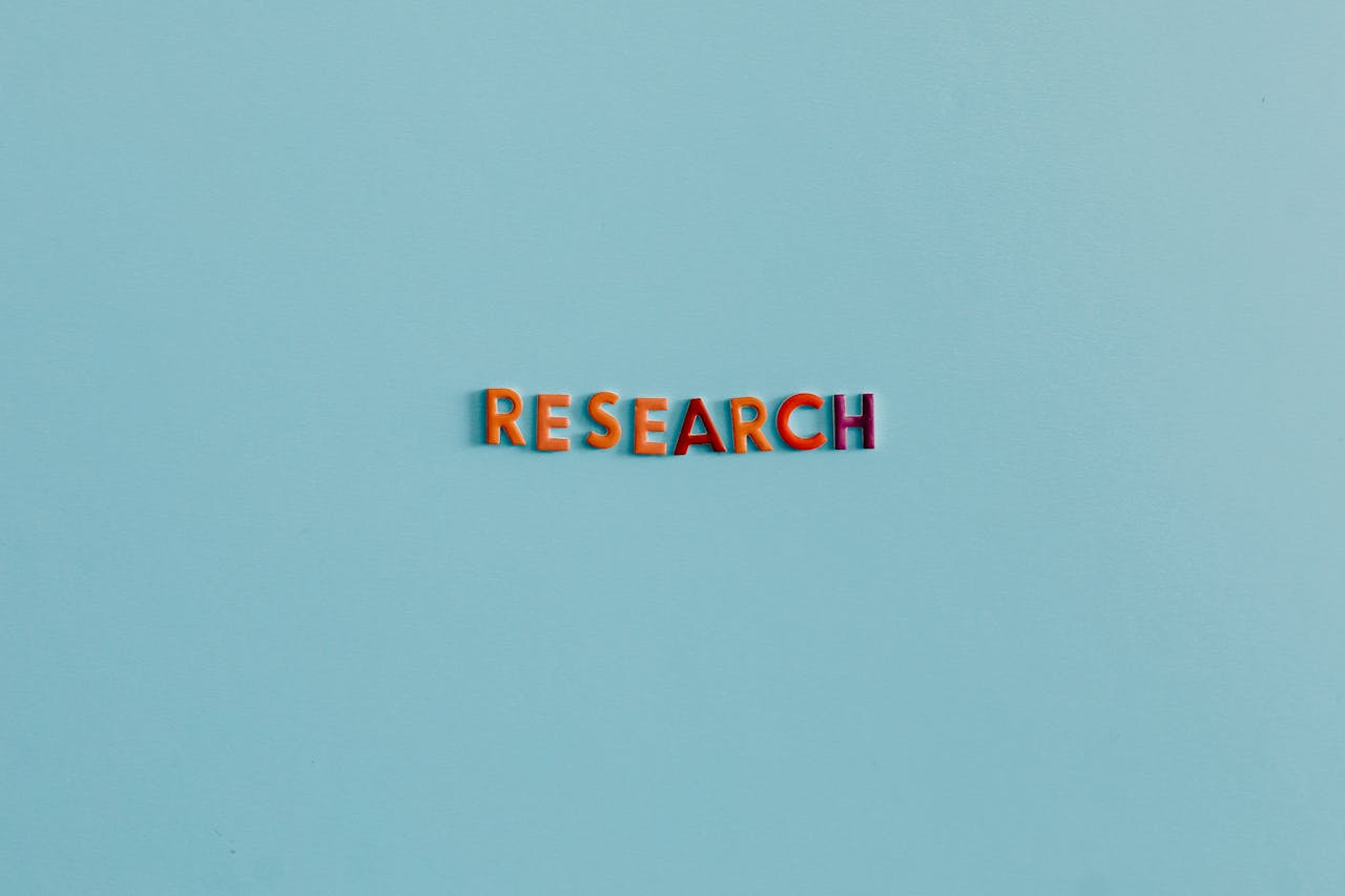 Colorful uppercase letters spelling RESEARCH on a soft blue background. Ideal for education and science topics.